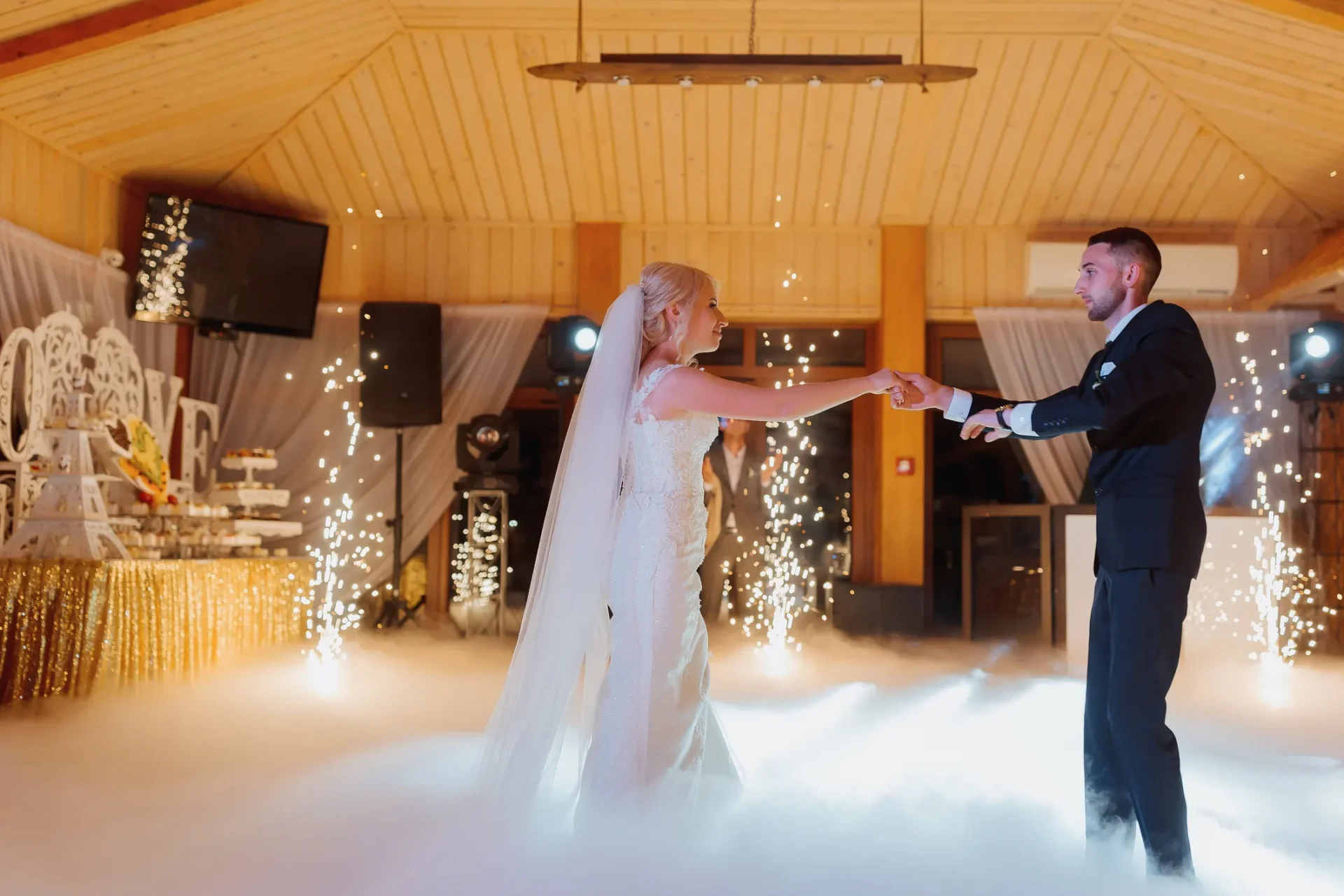 A bride and groom are dancing on the stage.