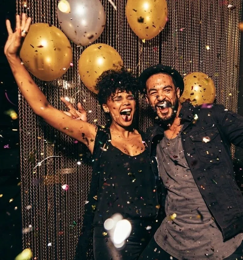 A man and woman are celebrating with balloons.