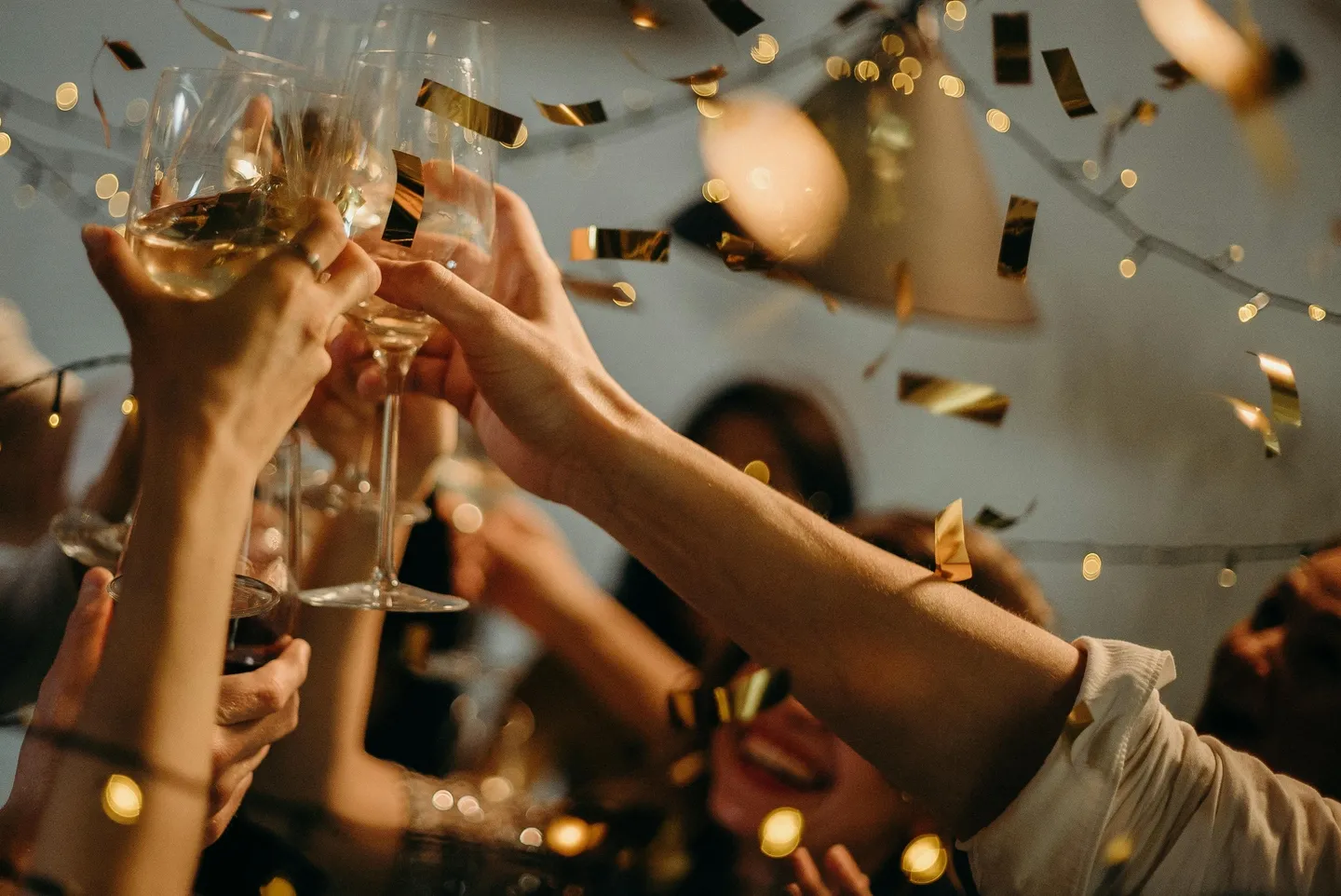 A group of people holding champagne glasses in their hands.